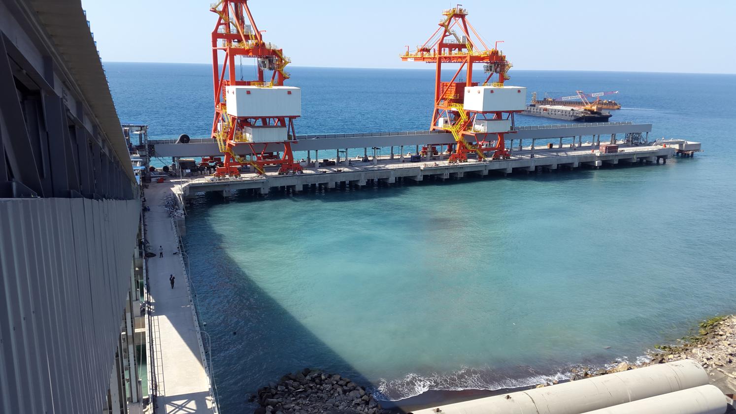 Red ship unloaders at a cargo berth